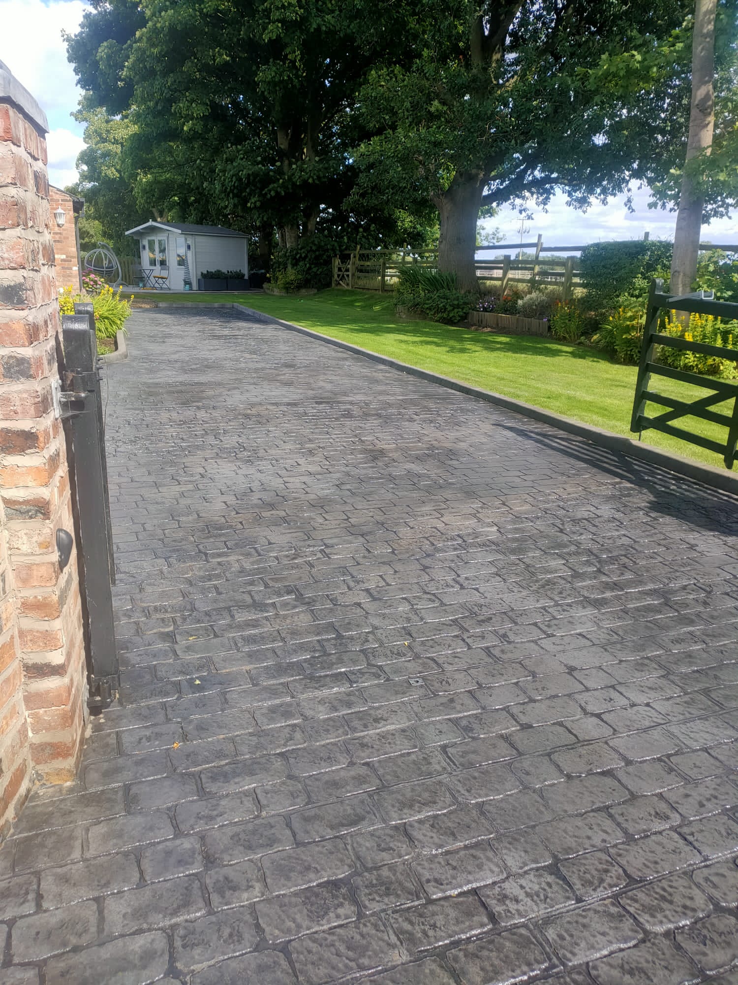 Red brick pattern imprinted driveway with circular feature, resealed